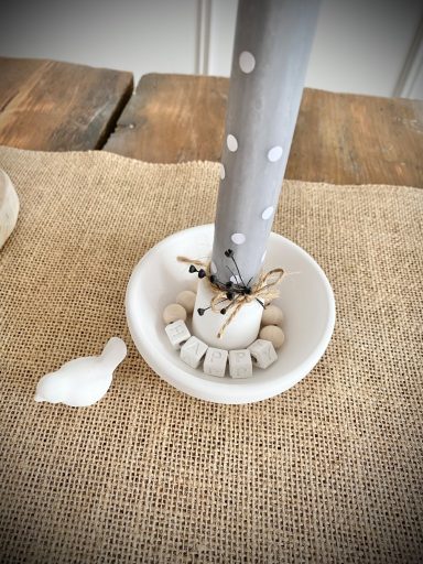 Weißer Kerzenhalter mit grauer Kerze und Mini-Vögelchen