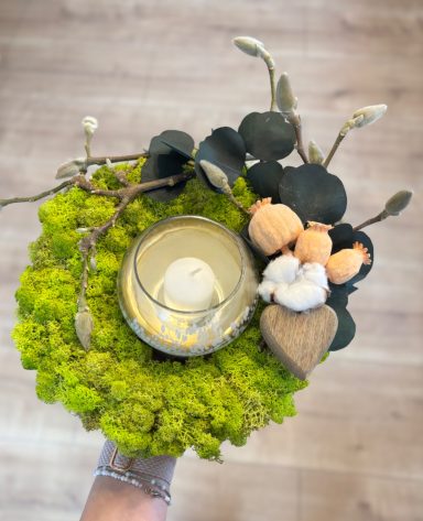 Grüner Mooskranz mit Naturmaterialien und Windlicht