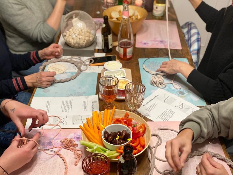 Gemeinsames Essen und Basteln an einem Tisch mit verschiedenen Snacks und Getränken.