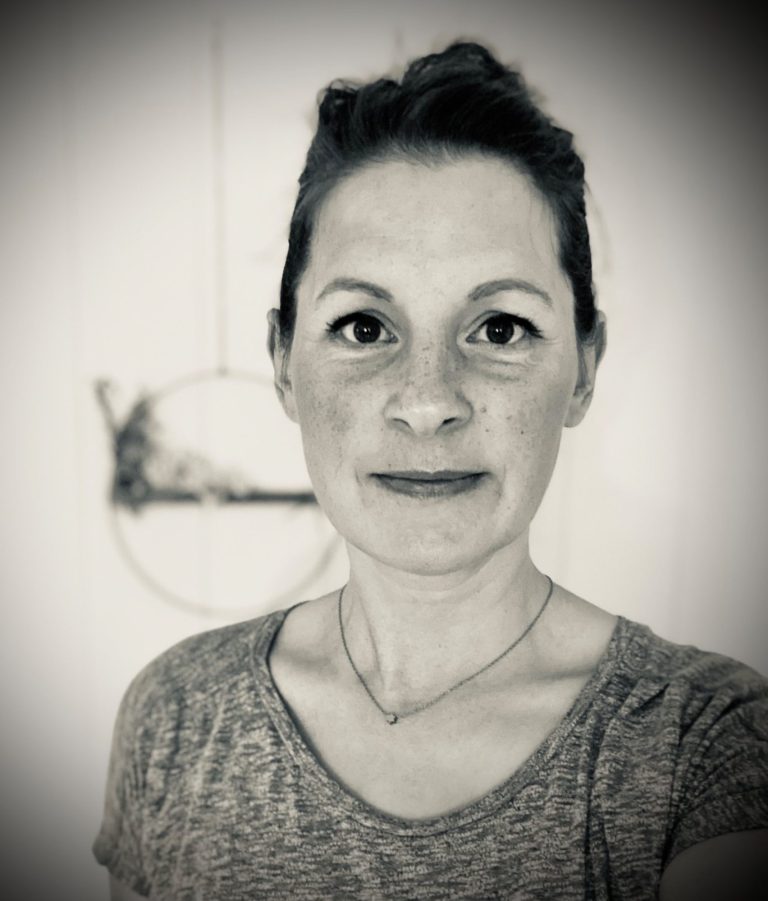 Porträt einer Person mit schlichter Kleidung und einem schemenhaften Hintergrund.